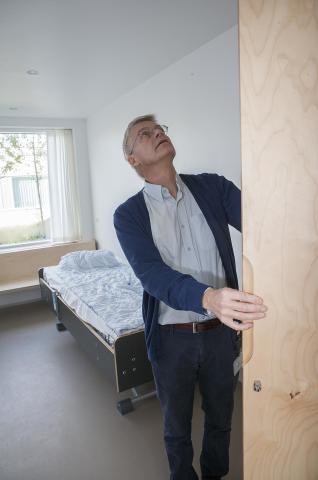 Ledende overlæge Michael Schmidt i et af patientværelserne på det nye sygehus. De er indrettet bl.a. med skæve håndtag og bløde tøjknager for at mindske suicidalrisikoen.