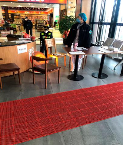 Indgangen til et motorvejscafeteria (man kan vel at mærke ikke få kaffe!). Fuld temperaturkontrol og vagter, men ingen kunder udover min kollega og mig. Læg mærke til, hvordan vagten i baggrunden bærer maske.