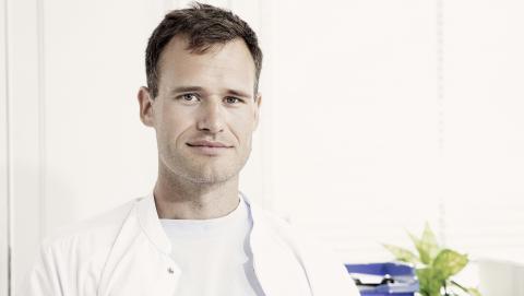 Hånden på hjertet - sådan foretrækker reservelæge Mikkel Skottings at hilse på patienterne. Han håber, at håndtrykket aldrig vender tilbage til sundhedsvæsenet. Foto: Robert Attermann.