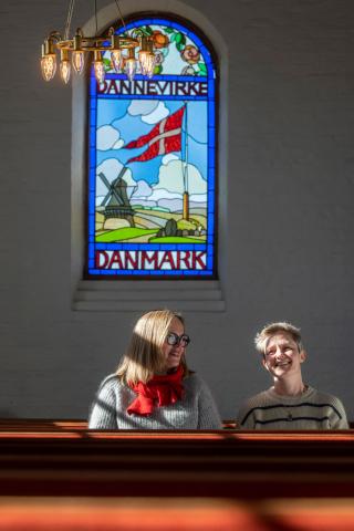 Læge Line Modin sammen med sin nye makker, Mette Geil, der er præst i frimenighedskirken i Rødding. Kirken, der blev indviet i 1909, bærer på mange måder præg af sin grænselandshistorie, blandt andet med dannevirkevinduet i sideskibet. Foto: Palle Peter Skov 