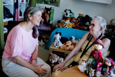 Læge Marianne Hansen er bostedslæge på Døgninstitutionen Løvstikkevej og Albatros. Her er hun hos Birthe Rantzau, der hver morgen omhyggeligt placerer alle sine dukker og tøjdyr det samme sted på den redte seng. Foto: Claus Boesen