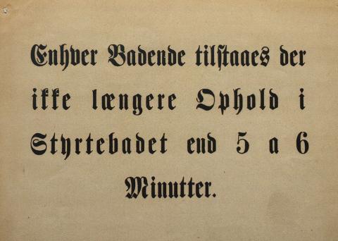 Den sorte røg fra de tidlige badeanstalters kuldrevne anlæg betød, at naboerne ikke kunne have vinduer åbne, uden at fint kulstøv lagde sig over det hele. Her er det røgen fra den hambroske badeanstalt ved Trinitatis Kirke. I forgrunden ses den ryddede plads efter det bortsanerede Brøndstrædekvarter, der stødte op til Vognmagergade. Billedet er fra 1911 (foto: Københavns Museum).